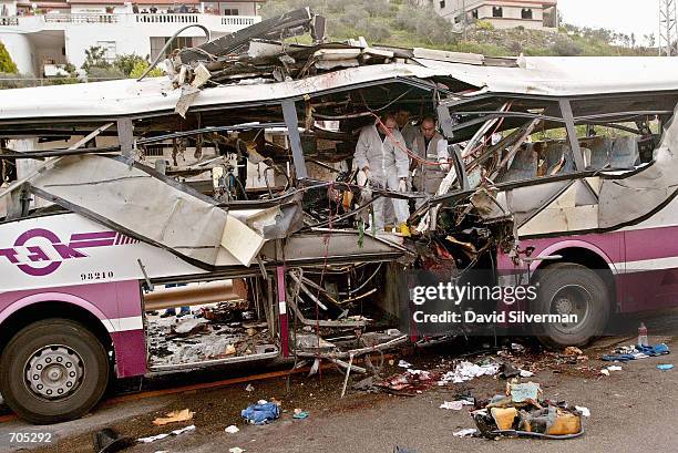 Israeli police investigators inspect a passenger bus destroyed by a Palestinian suicide bomber March 20 who blew himself up on the bus filled with...