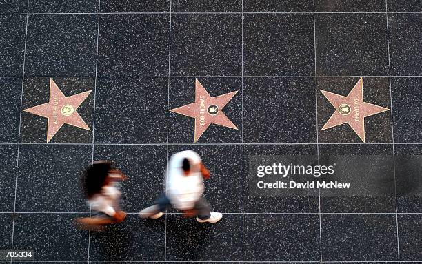 Pedestrians pass stars on the Walk of Fame sidewalk on Hollywood Boulevard next to the new Hollywood and Highland complex March 6, 2002 in Hollywood,...