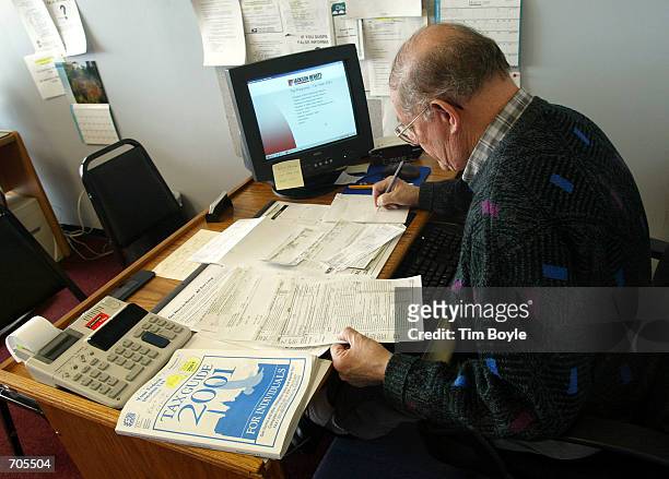 Income tax preparer Bob Ludtke prepares a clients tax return at a Jackson Hewitt tax service preparation office March 6, 2002 in Mount Prospect, IL....