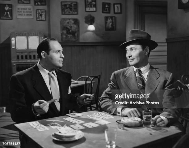 American actors Richard Karlan as Sy, and Barry Sullivan as Steve Keiver in a publicity still for 'No Questions Asked ', directed by Harold F. Kress,...