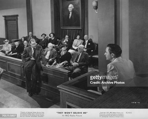 Defense Attorney Cahill cross-examines Larry Ballentine during his trial for murder, in a publicity still for Irving Pichel's film noir, 'They Won't...