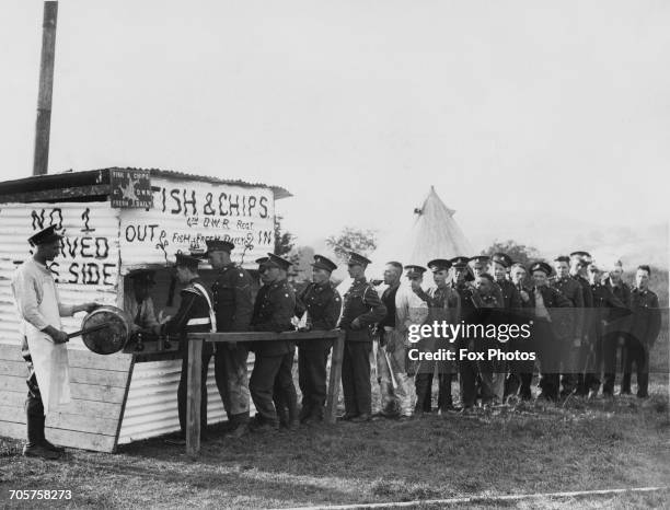 Soldiers of the Duke of Wellington's Regiment line up for Fish and Chips from a mobile shop set up in the Wathgill Camp during Territorial manoeuvers...