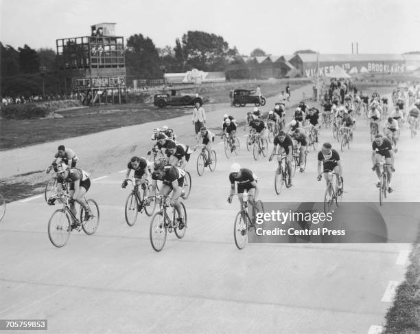 Spectators line the track as the racing cyclists take part in the road race trials for the Cycling World Championships held at the Brooklands motor...