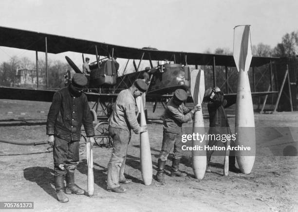 Air mechanics with a selection of armaments carried by the Gotha GV long range heavy bomber of the Luftstreitkrafte on 1 March 1918 at an airfield in...