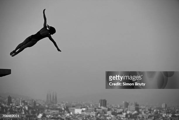 Silhouette of diver Tracey Miles of Great Britain is captured high over the Sagrada Familia of Antoni Gaudí during a diving competition prior to the...