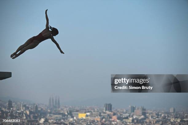 Silhouette of diver Tracey Miles of Great Britain is captured high over the Sagrada Familia of Antoni Gaudí during a diving competition prior to the...