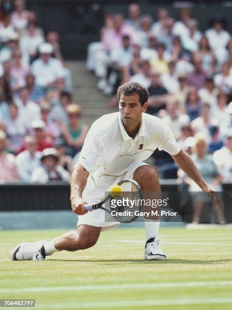 Pete Sampras of the United States drops low to make a backhand against Tim Henman in their Semi Final match during the Wimbledon Lawn Tennis...