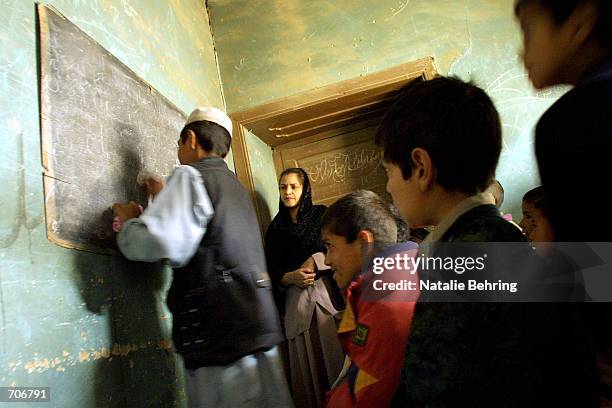 Afghan boys attend their first class on the first day of the official school year March 23, 2002 at the Amir Dost Mohammad Khan Secondary School in...
