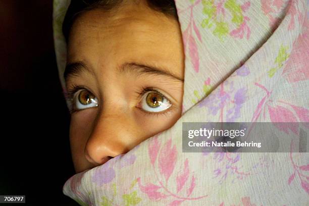 An Afghan school girl listens to a lesson about the letters of the Dari alphabet March 23, 2002 at the Amir Dost Mohammad Khan Secondary School on...