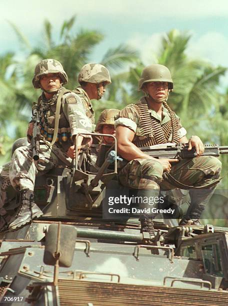Group of Philippine National Polices Special Action Force soldiers ride atop an Armed Personal Carrier March 24, 2002 at a base on the outskirts of...