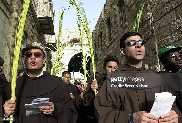Group of monks sing songs and wave palm fronds in Jerusalem March 24, 2002 as they celebrate Palm Sunday by retracing the steps of Jesus Christs...