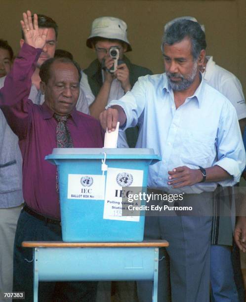 East Timorese independence leader Xanana Gusmao casts his vote into the ballot box while his rival Francisco Xavier Do Amaral waves, April 14, 2002...