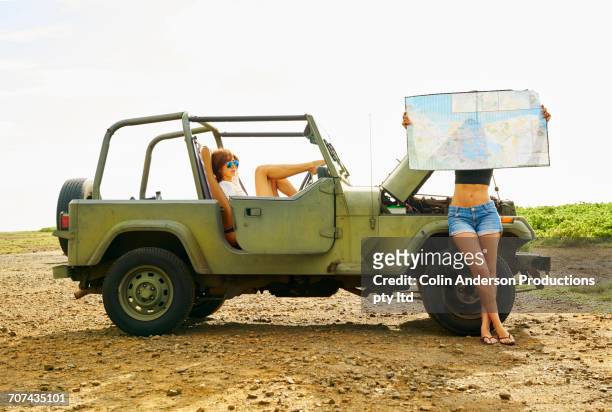 women reading map in off-road vehicle - covered car stock-fotos und bilder