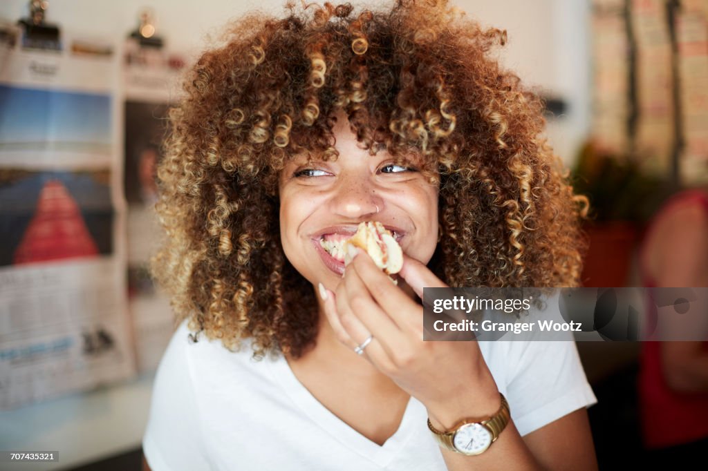 Black woman biting sandwich