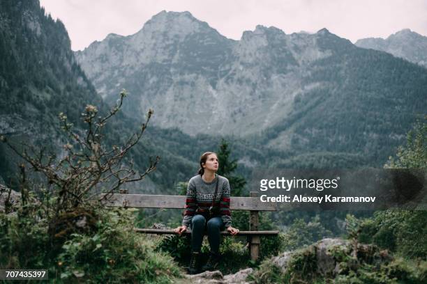 caucasian woman sitting on bench in mountains - frau ruhige szene berge stock-fotos und bilder