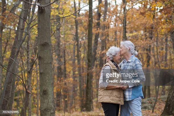 caucasian women kissing outdoors in autumn - gay seniors stock pictures, royalty-free photos & images