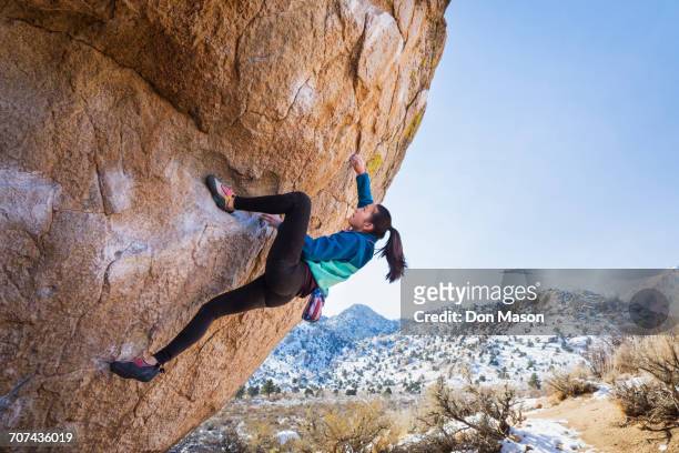 mixed race girl climbing rock - rock climber stockfoto's en -beelden