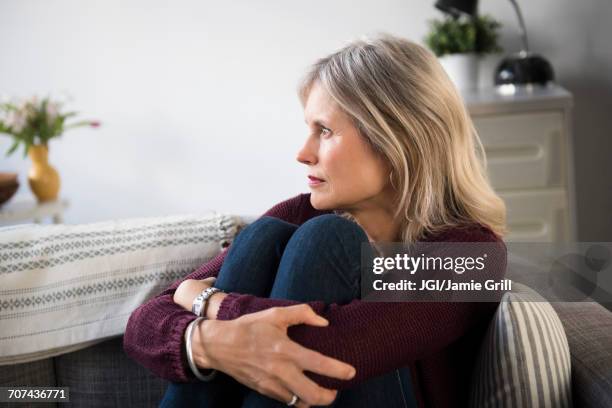 worrying caucasian woman hugging legs - smart stockfoto's en -beelden