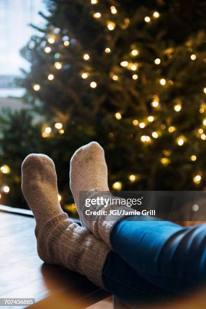 socks of caucasian woman with feet on table near christmas tree - feet christmas stock pictures, royalty-free photos & images