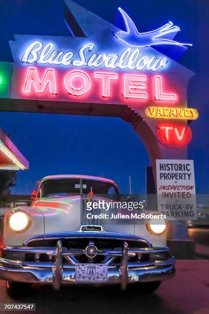 old-fashioned car in motel parking lot at night - motel stock-fotos und bilder