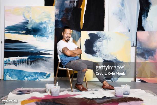 pacific islander painter admiring canvas on floor - artista stock pictures, royalty-free photos & images