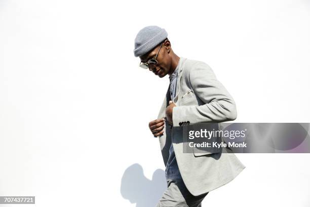 black man wearing sunglasses adjusting jacket - moda foto e immagini stock