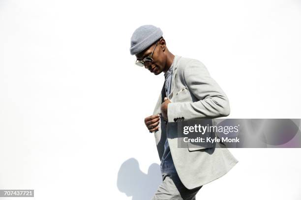 black man wearing sunglasses adjusting jacket - zwart jak stockfoto's en -beelden