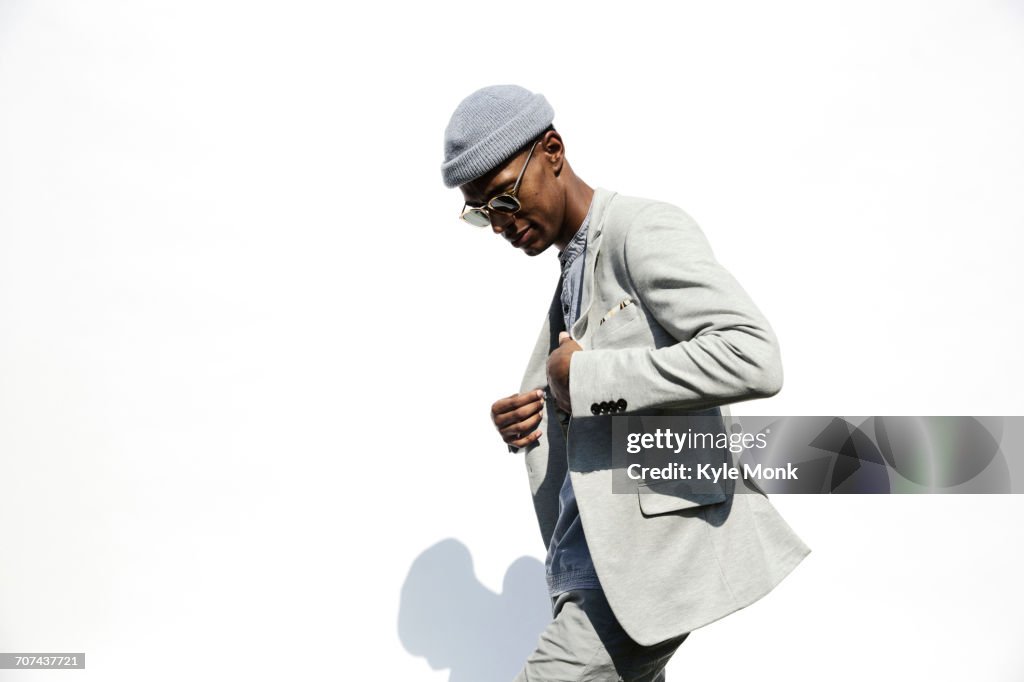 Black man wearing sunglasses adjusting jacket