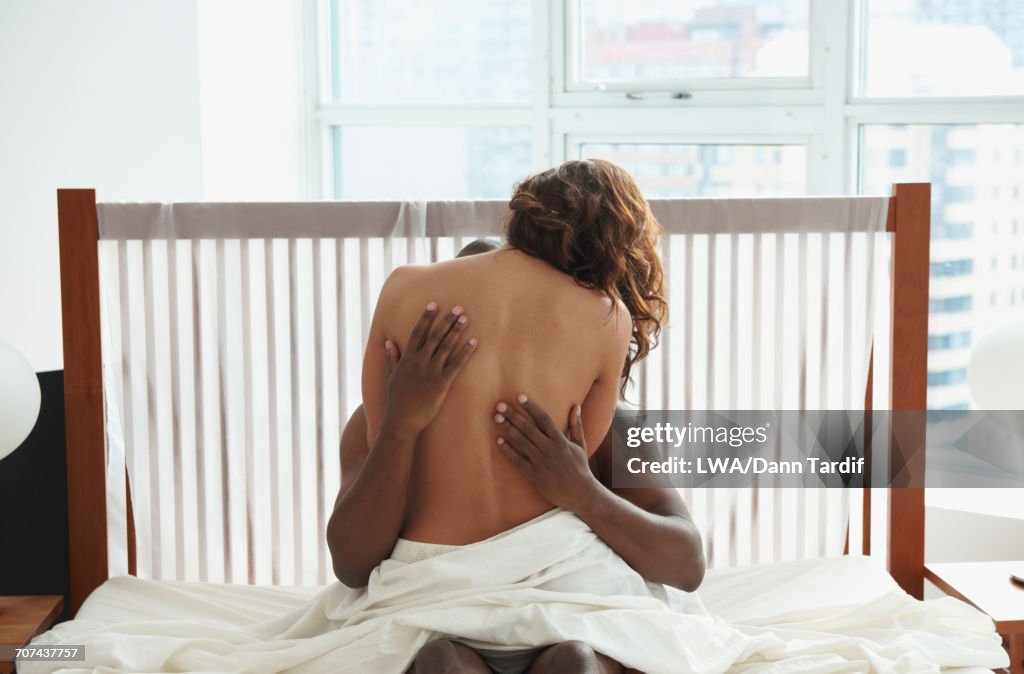 Woman and man hugging in bed