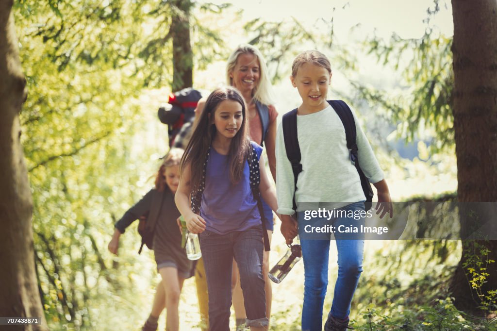 Mother and daughters hiking in woods