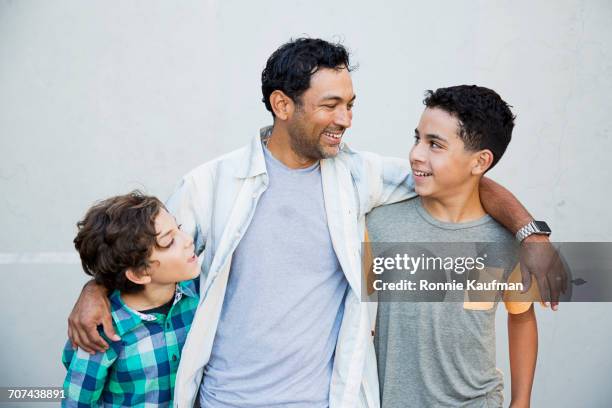 hispanic father hugging sons - gezin met twee kinderen stockfoto's en -beelden