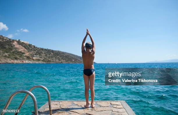 caucasian boy preparing to swim in lake - herakleion stock pictures, royalty-free photos & images