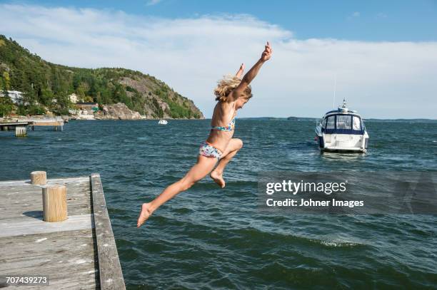 woman jumping into sea - norrkoping stock pictures, royalty-free photos & images