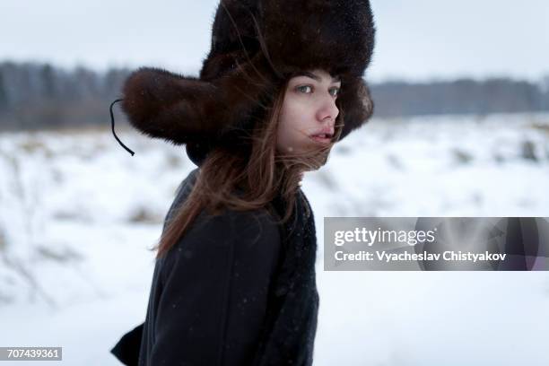 serious caucasian woman wearing fur hat and coat in winter - fur hat stock pictures, royalty-free photos & images