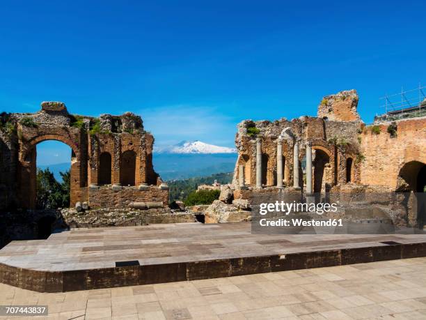 italy, sicily, taormina, ruins of teatro greco with mount etna in the background - teatro greco taormina stock-fotos und bilder