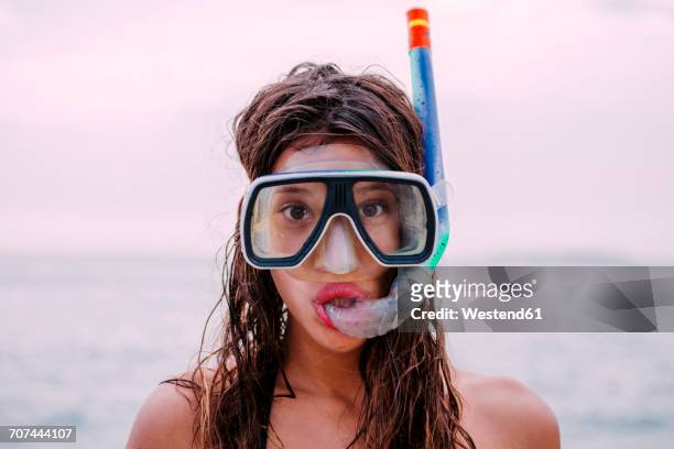 young woman with diving goggles and snorkel pulling funny faces - mask joke stockfoto's en -beelden
