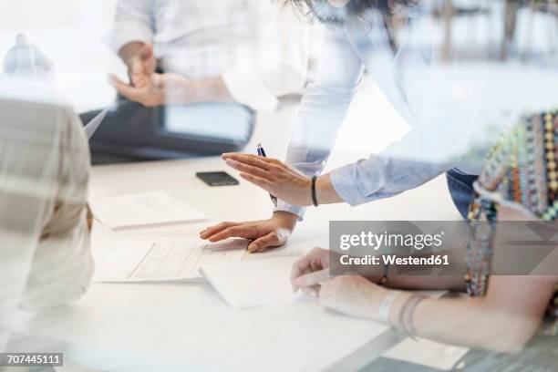 business meeting in conferene room behind glass wall - glass reflection in office stock-fotos und bilder