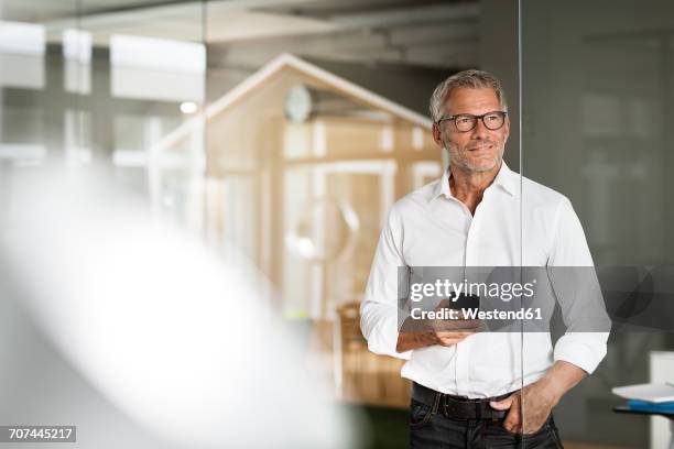 businessman with cell phone in office - stile stock-fotos und bilder