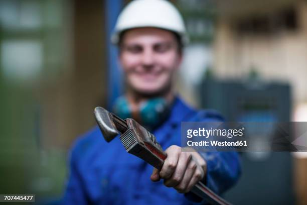 worker in factory holding wrench tool - adjustable wrench imagens e fotografias de stock