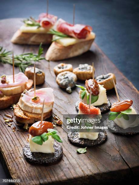 various appetizers on wooden board - tapas stock-fotos und bilder