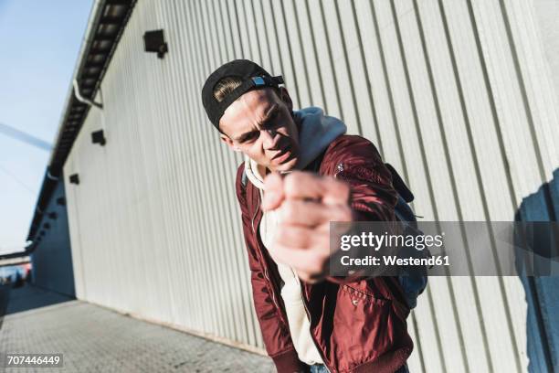 portrait of aggressive young man making a fist - raid stock-fotos und bilder