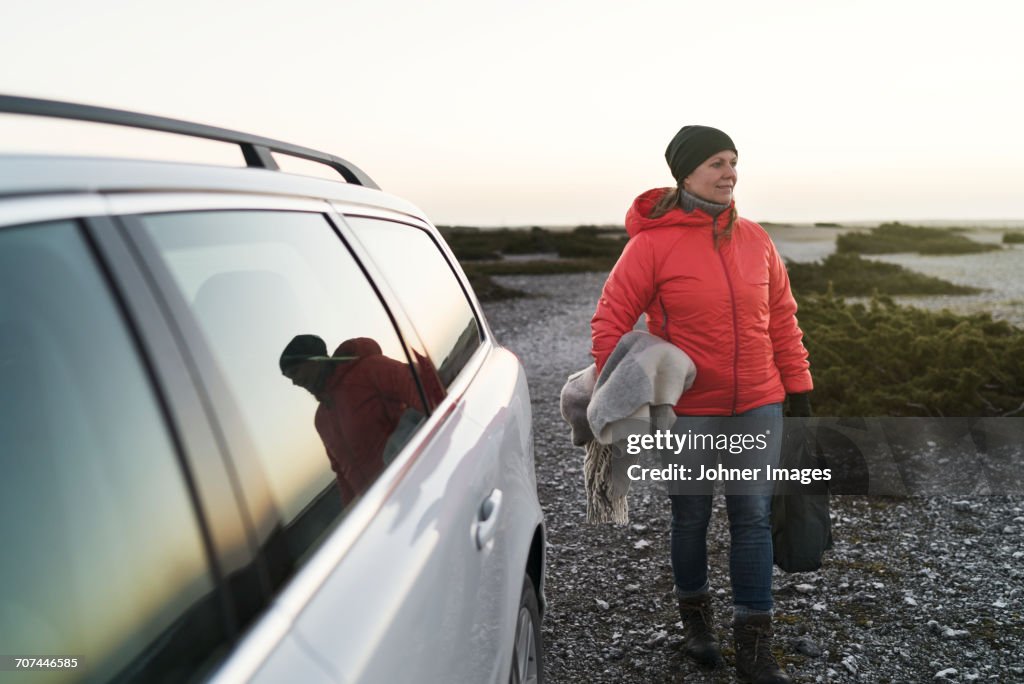 Woman at sea near car