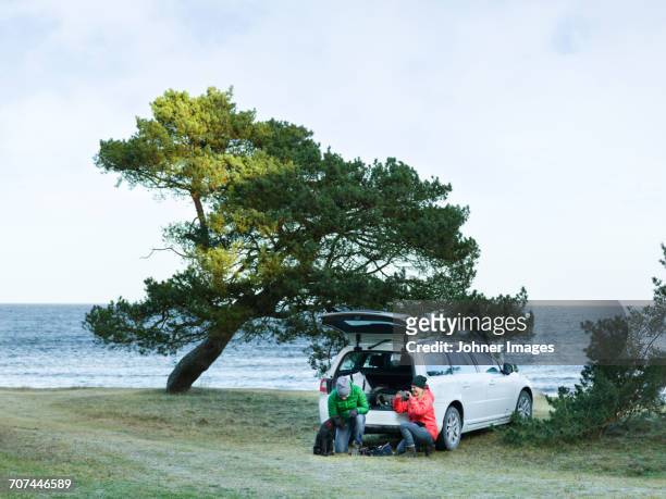 people near car at sea - car scandinavia stock pictures, royalty-free photos & images