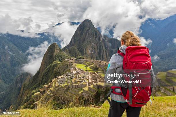 peru, andes, urubamba valley, tourist with red backpack at machu picchu with mountain huayna picchu - backpacker woman stock-fotos und bilder