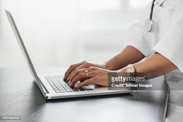 female doctor using laptop - clock person desk stockfoto's en -beelden