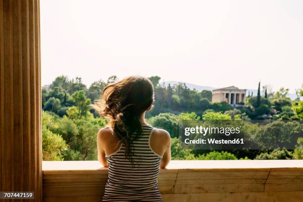 greece, athens, woman looking to the hephaisteion from stoa of attalos in the agora - oude agora stockfoto's en -beelden