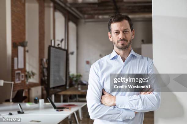 portrait of confident businessman in office - mature adult focus on foreground stock-fotos und bilder