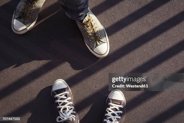 feet of couple wearing sneakers - looking down at shoes stock pictures, royalty-free photos & images