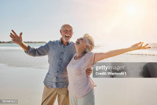 happy senior couple on the beach - older couple hugging on beach stock pictures, royalty-free photos & images