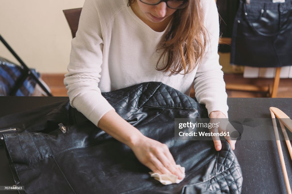 Woman cleaning leather jacket